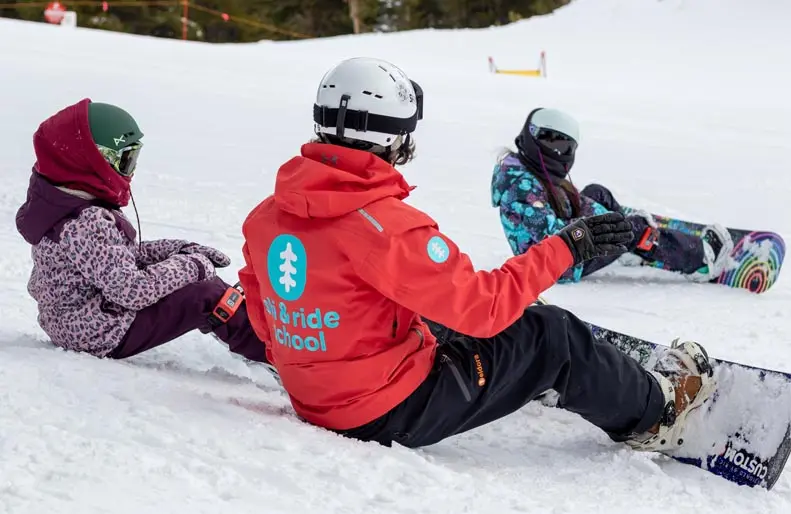 snowboard instructor with two young students