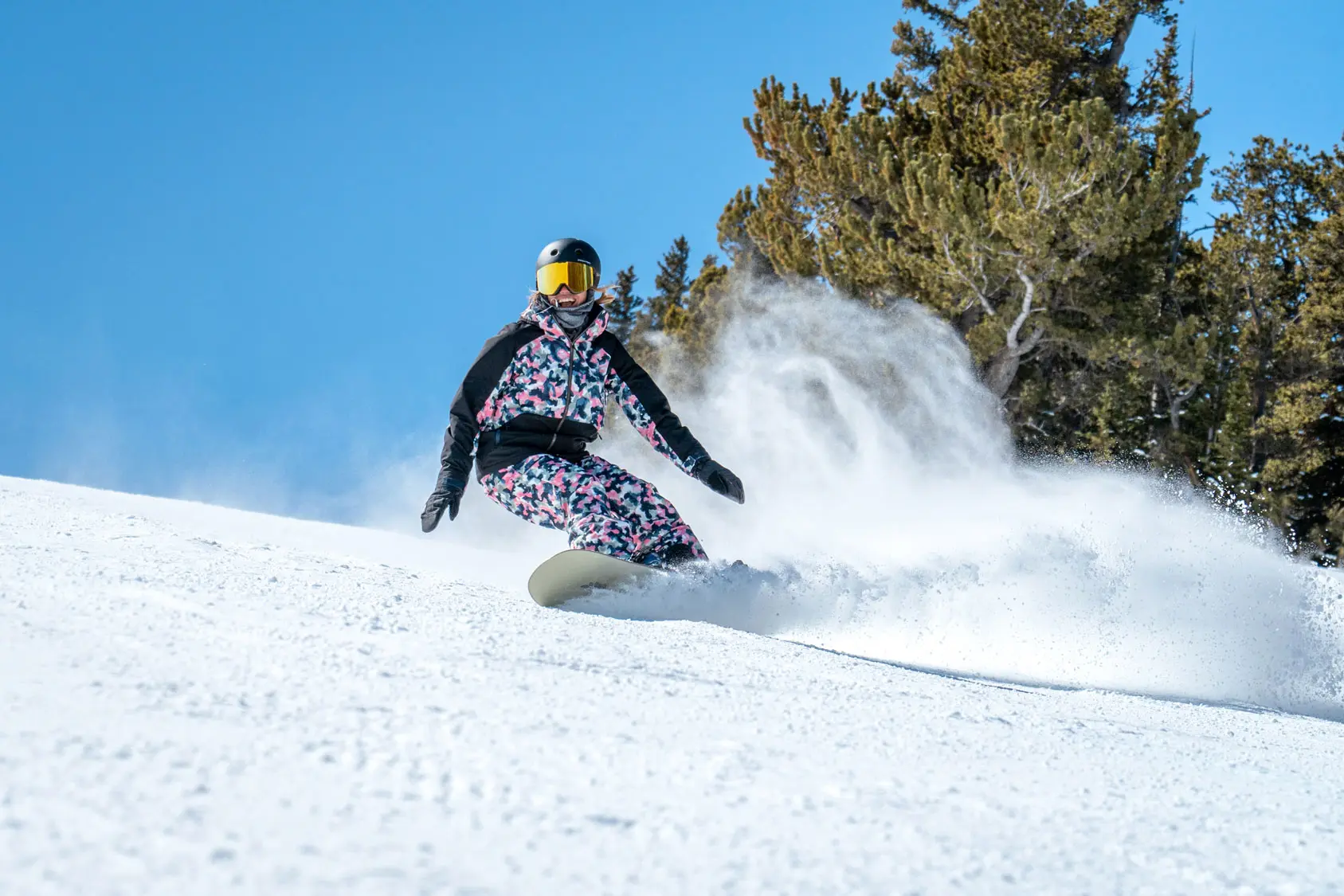 snowboarder smiles with a blue sky in the background