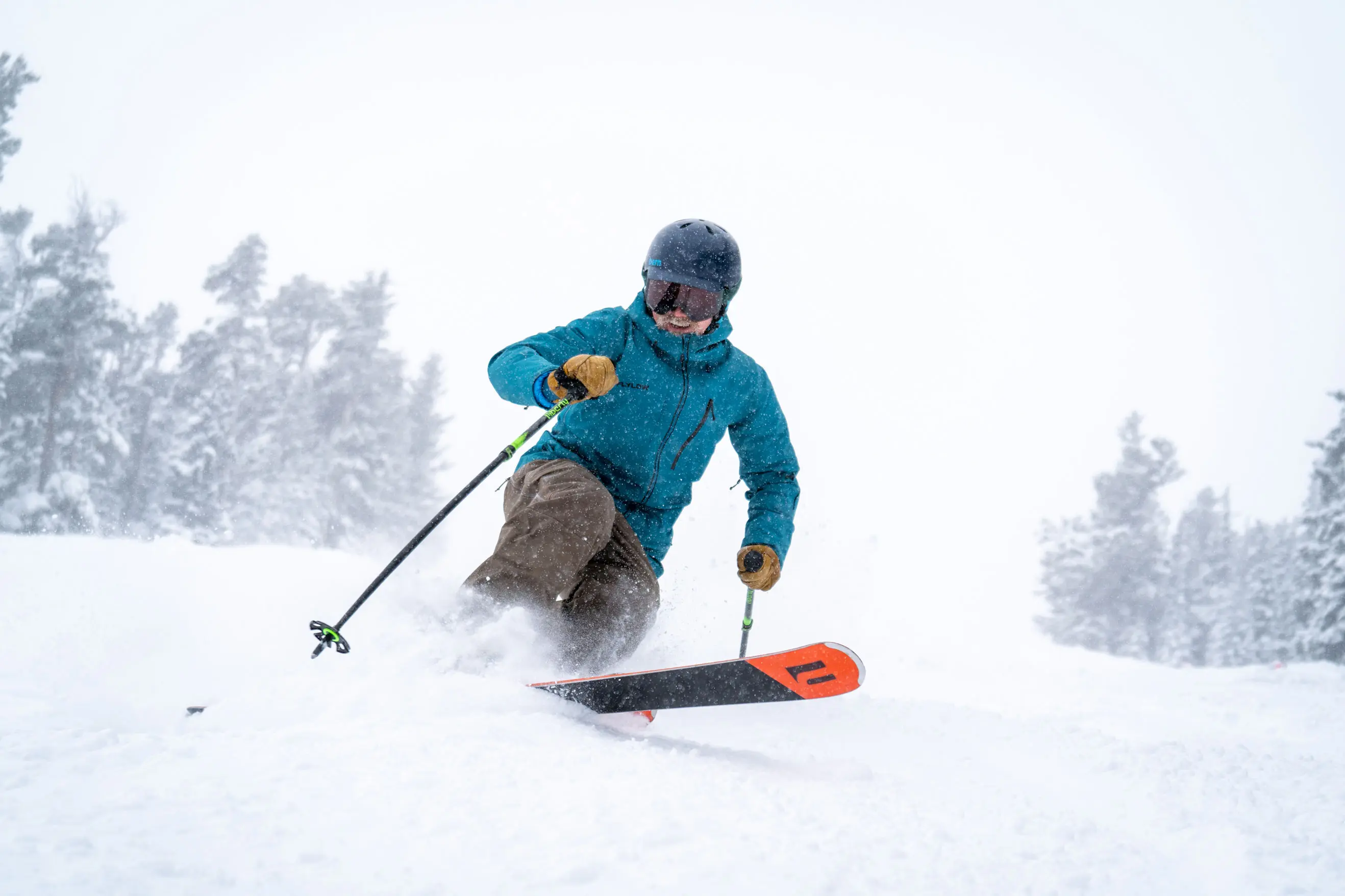 Man tele skis while wearing a blue jacket