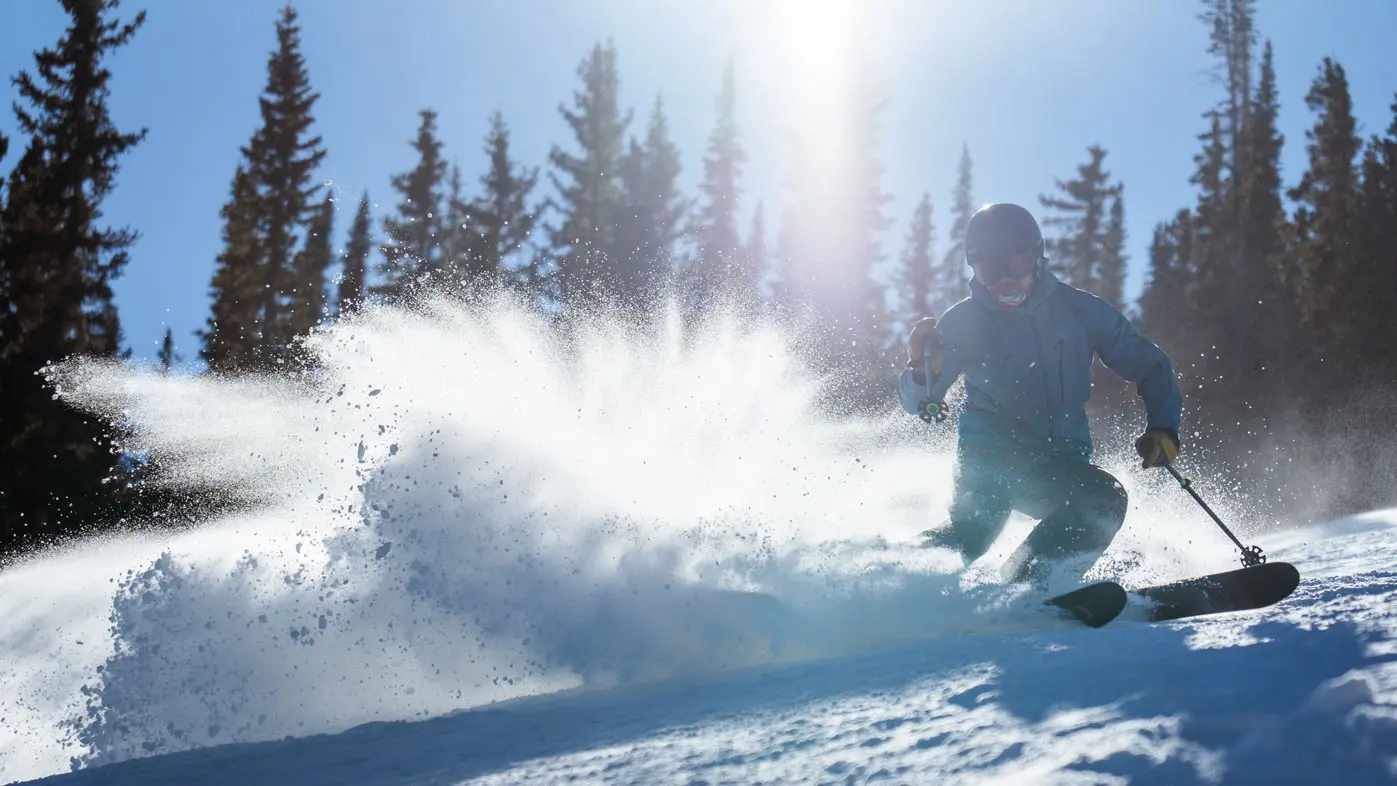 Man tele skis while wearing a blue jacket