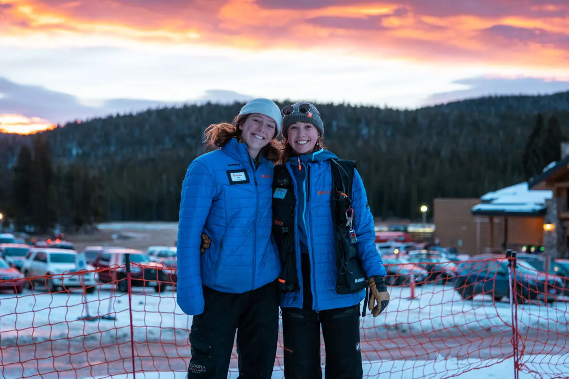 two employees smile at the camera